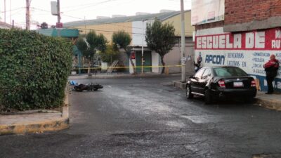 TRAGEDIA: Motociclista sin casco intenta rebasar un auto, choca contra otro estacionado y muere