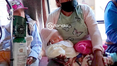 CONMOVEDOR. Captan a abuelita cargando en sus brazos a un bebé que requiere de oxígeno para respirar