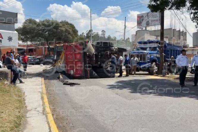 URGENTE: Camión de volteo termina ‘recostado’ y riega toneladas de materiales